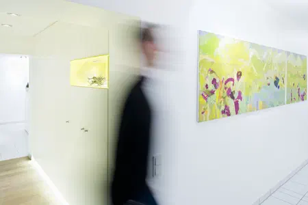 Eine Person huscht durchs Bild. An den Wänden moderne Kunst.